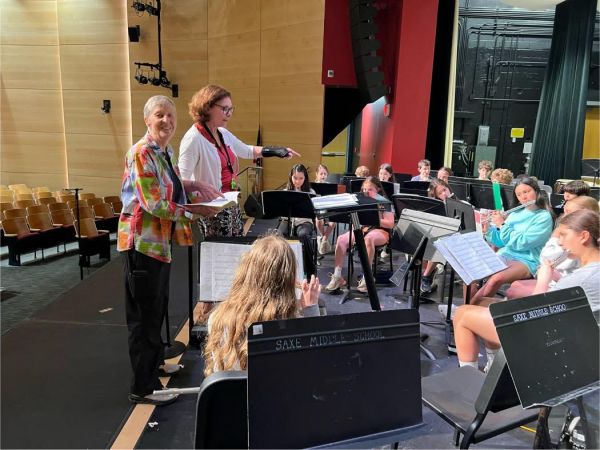 A photo of the Gwyneth Walker, Janet Rosen, and the Saxe 6th Graade Band